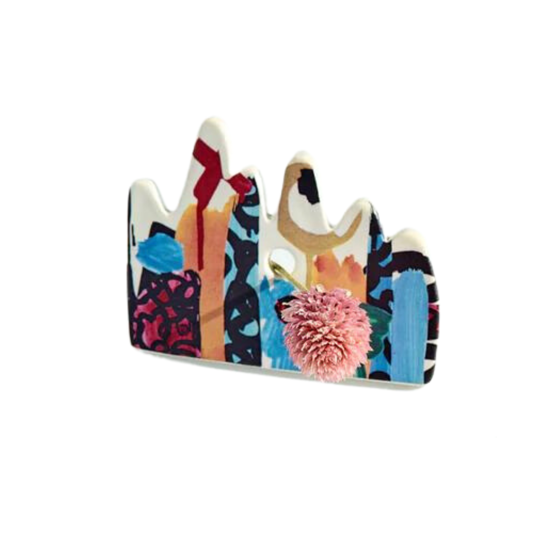 Wandering Bud collaborated with a local artist to develop a handmade ceramic roach clip that holds cannabis joints. This blunt holder features a drippy abstract city scape ceramic decal.
