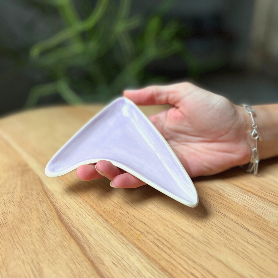 Our boomerang tray provides the perfect surface to pour out a cannabis grinder, and the built-in spout funnels weed into the pipe bowl, mess-free. Our ceramic smoke trays and accessories are handmade by a woman-owned studio in the USA. This purple lilac weed tray doubles as art in your home and complements home decor.