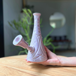 A ceramic bong that smokes like a dream and complements interior design; this water pipe is handmade by a woman-owned studio in the USA. Flora is a purple ceramic water pipe that doubles as art in your home and pairs well with your favorite smoke accessories. Smoke your favorite bud from this ceramic bong in Lilac.