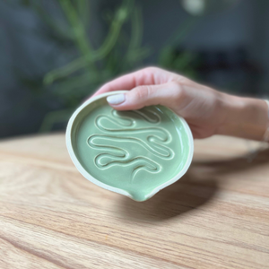 Millie is a ceramic grinder tray that grinds weed and funnels cannabis into a pipe bowl, this smoke accessory is handmade by a woman-owned studio in the USA. Millie in moss green is a ceramic grinder that grinds cannabis, easily funnels weed into a pipe or bong bowl, is easy to clean and keeps your hands mess free.
