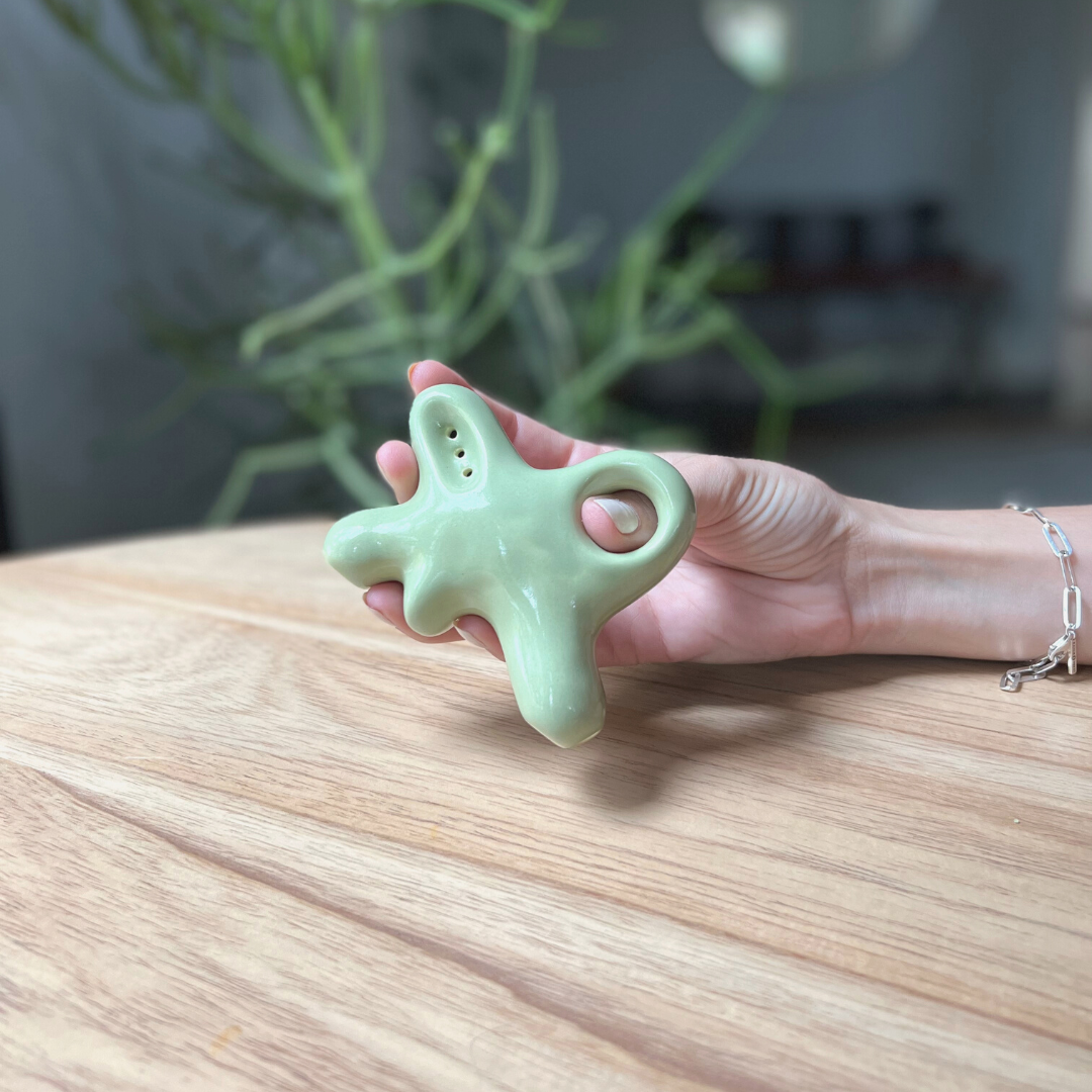 A ceramic abstract pipe that smokes like a dream and complements interior design; this dry pipe is handmade by a woman-owned studio in the USA. Nebula is a green ceramic pipe that doubles as art in your home and pairs well with your favorite smoke accessories. Smoke your favorite bud from this ceramic hand pipe in Moss.